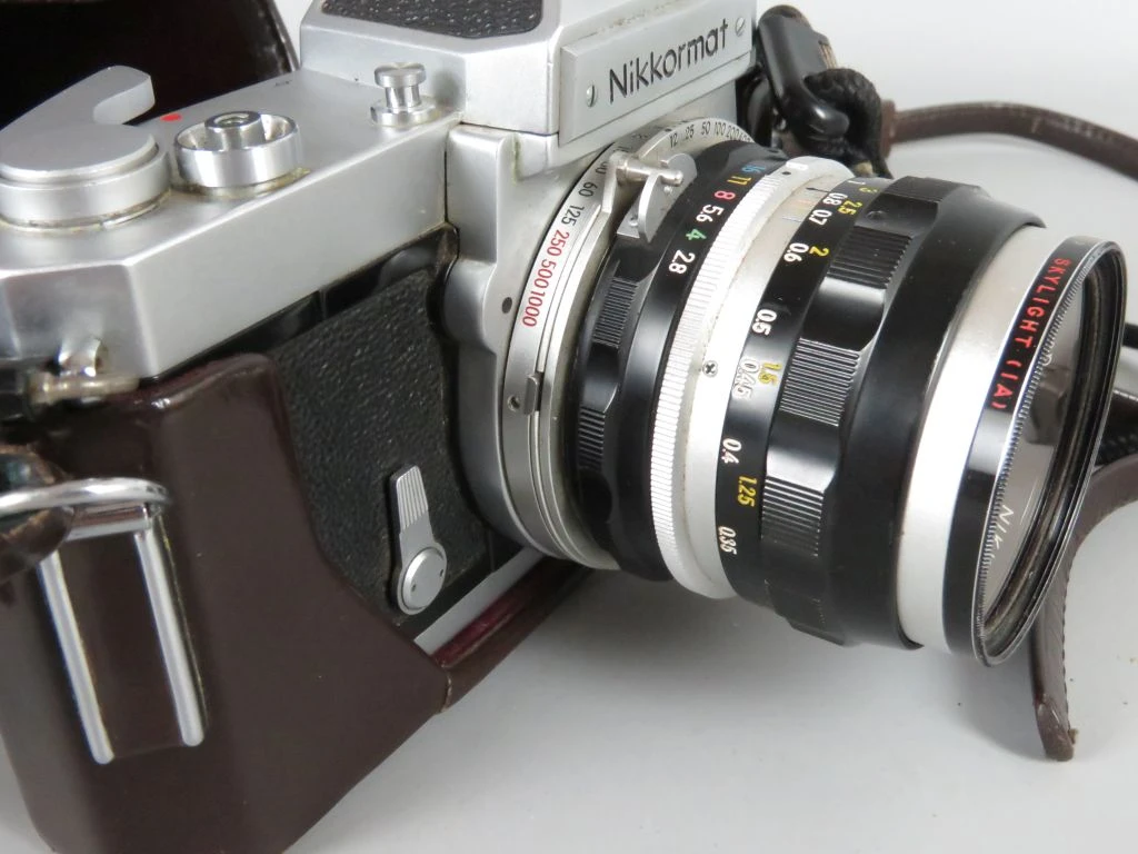 Nikkormat vintage analoge camera met lens en leren hoes