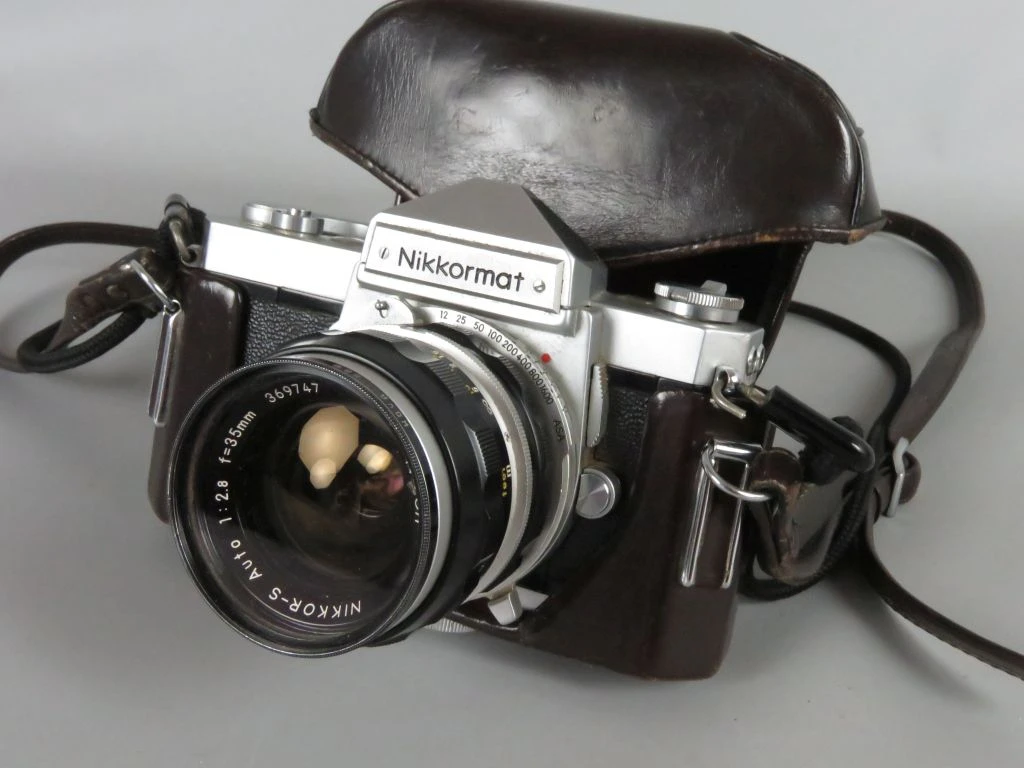 Nikkormat vintage analoge camera met lens en leren hoes