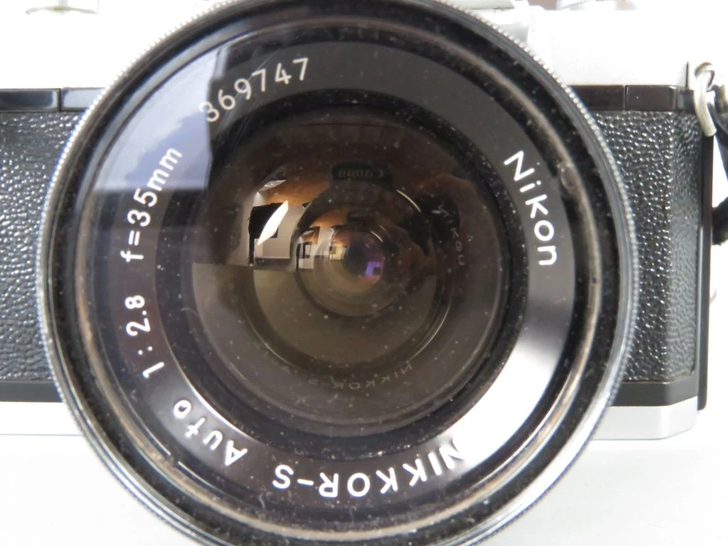 Nikkormat vintage analoge camera met lens en leren hoes