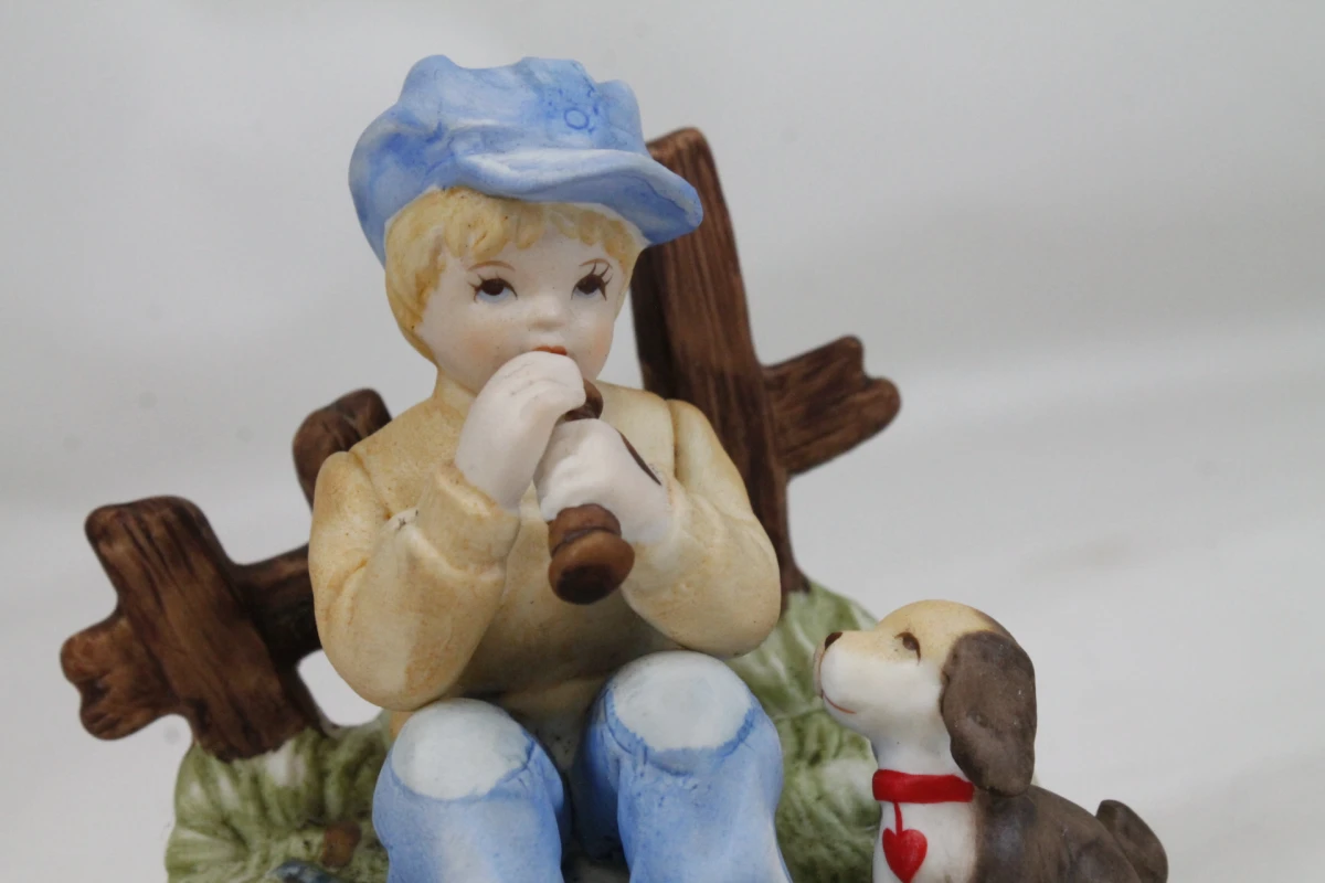 Vintage biscuit porseleinen beeldje: Zittende jongen