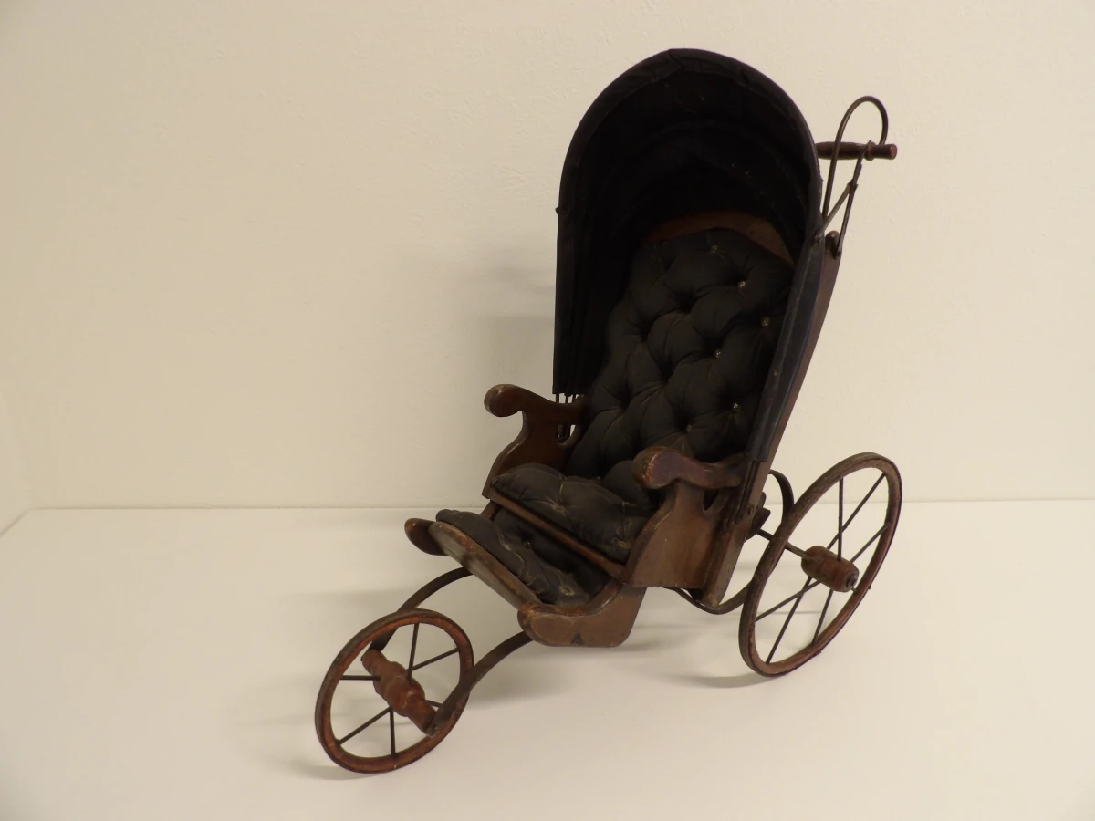 Antieke houten kinderwagen met stoffen bekleding