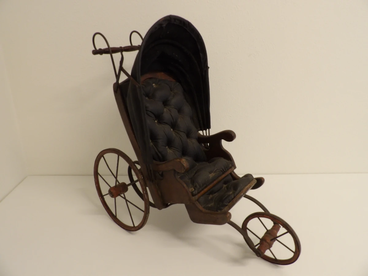 Antieke houten kinderwagen met stoffen bekleding