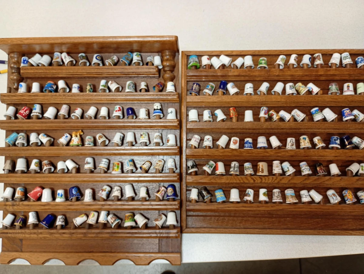 Verzameling porseleinen vingerhoedjes in houten display
