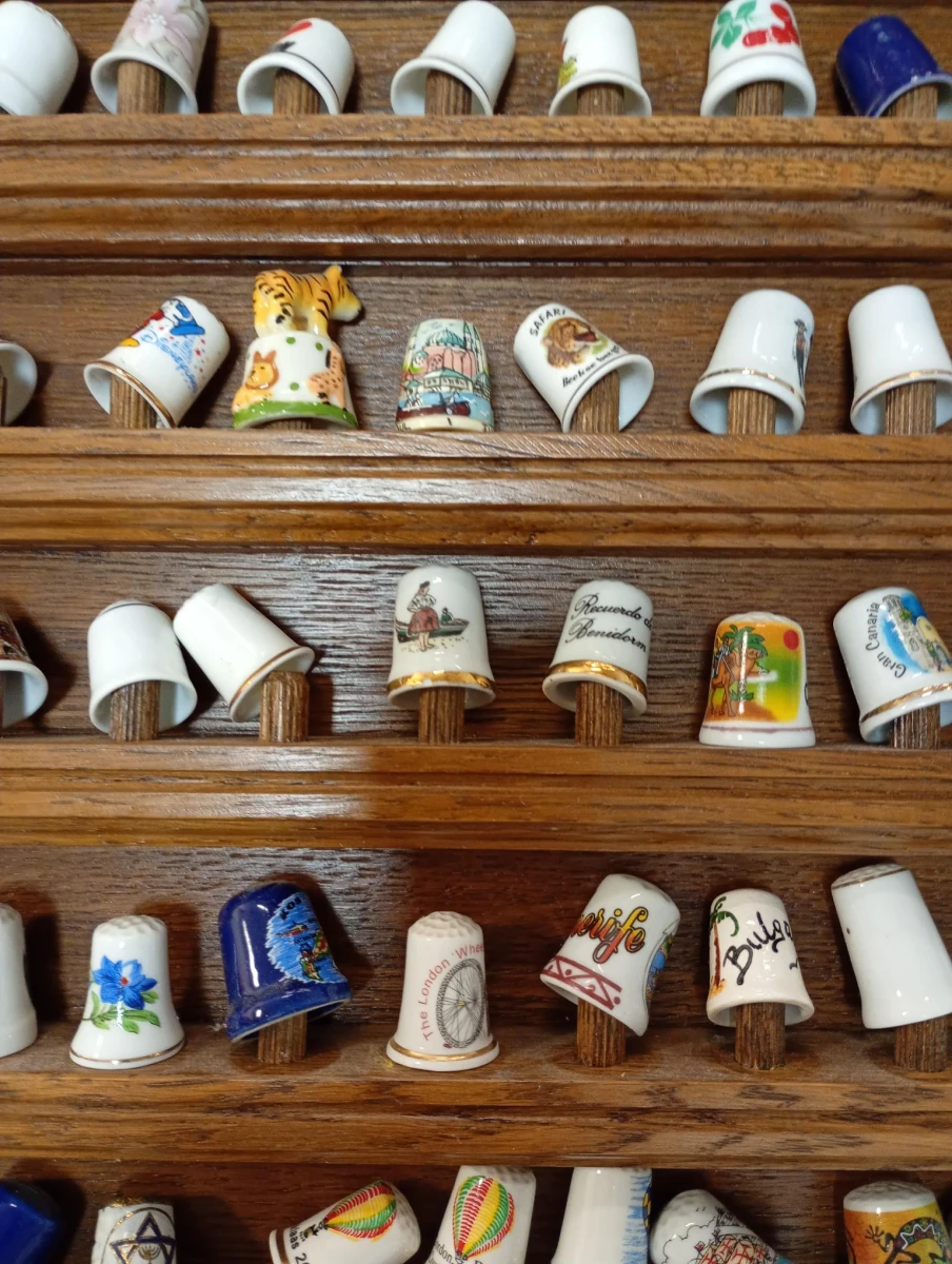 Verzameling porseleinen vingerhoedjes in houten display