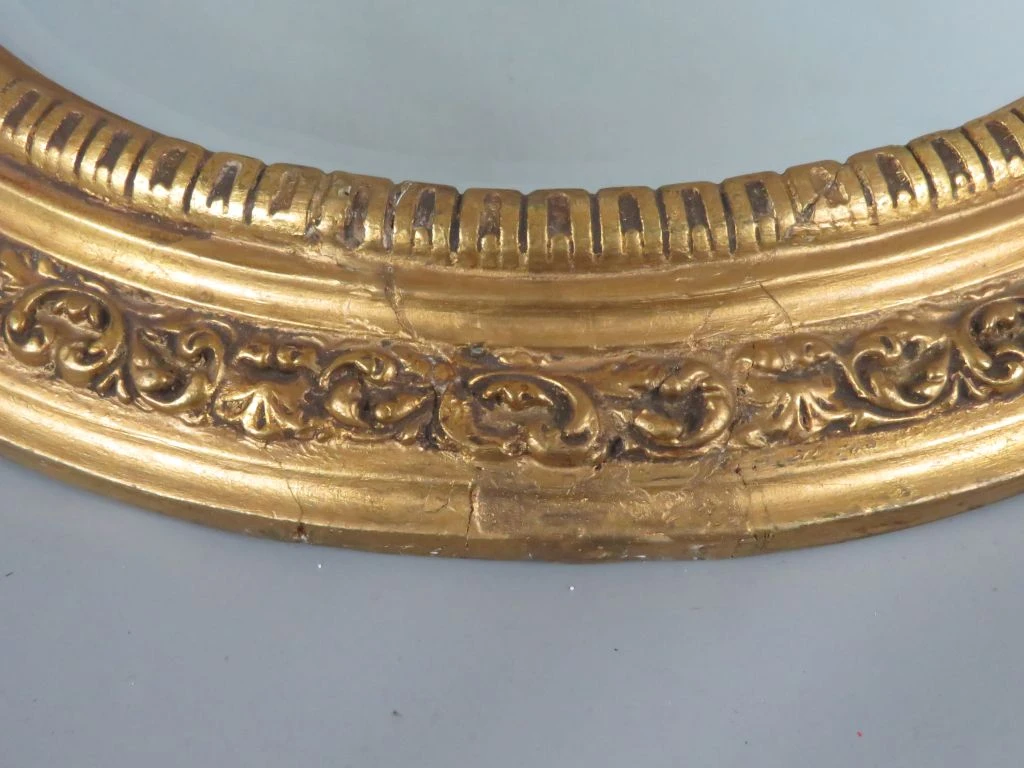 Ronde gouden spiegel met decoratieve lijst