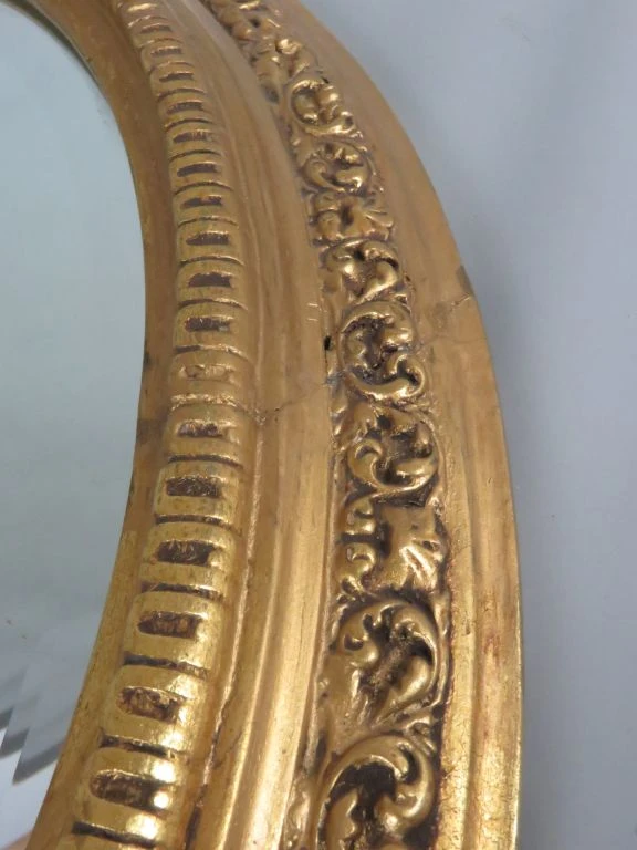 Ronde gouden spiegel met decoratieve lijst