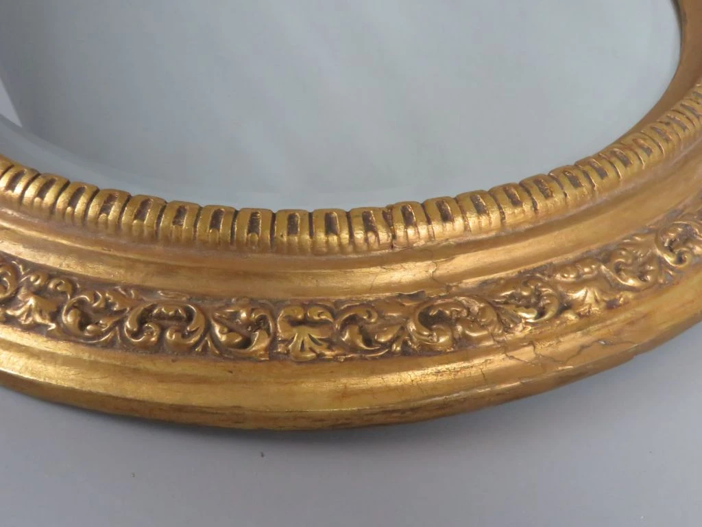 Ronde gouden spiegel met decoratieve lijst