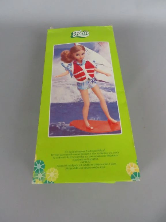 Vintage Fleur pop met surfplank en extra kleding in doos