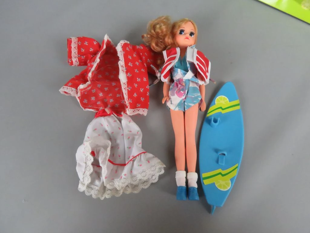 Vintage Fleur pop met surfplank en extra kleding in doos