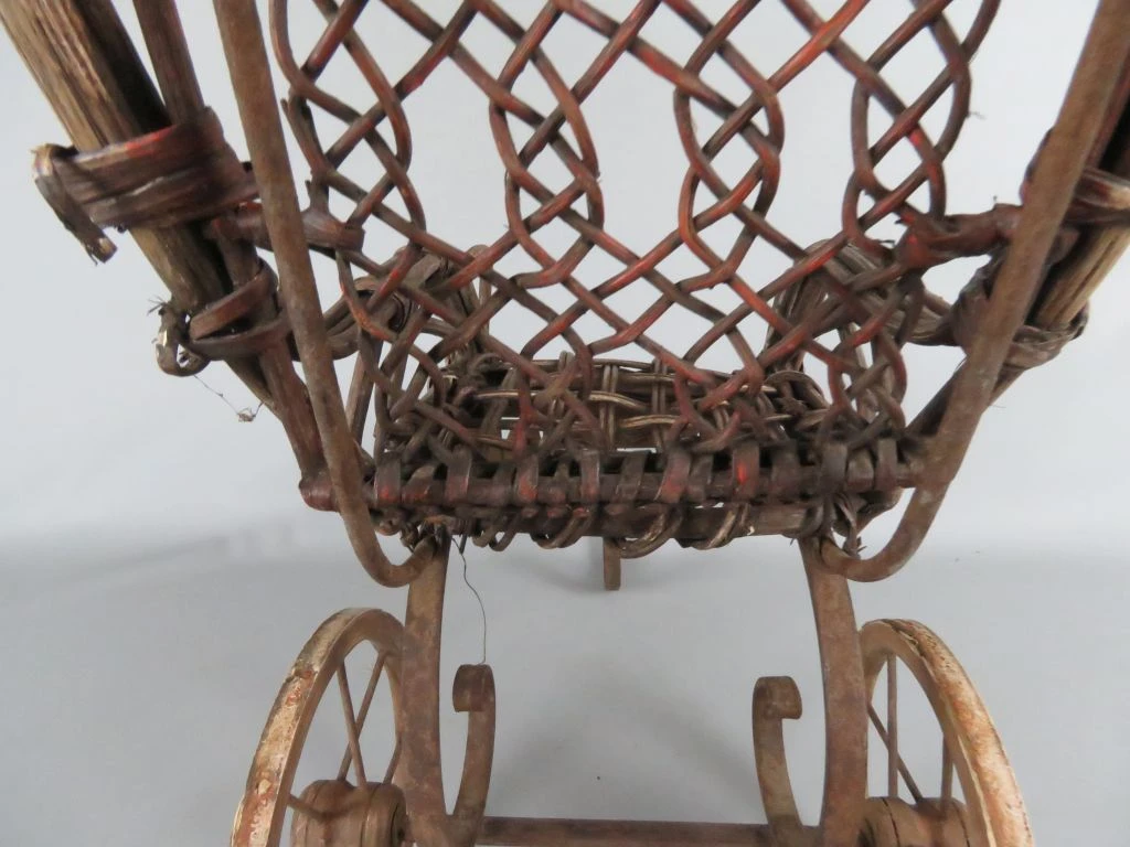 Antieke kinderwagen van riet en hout