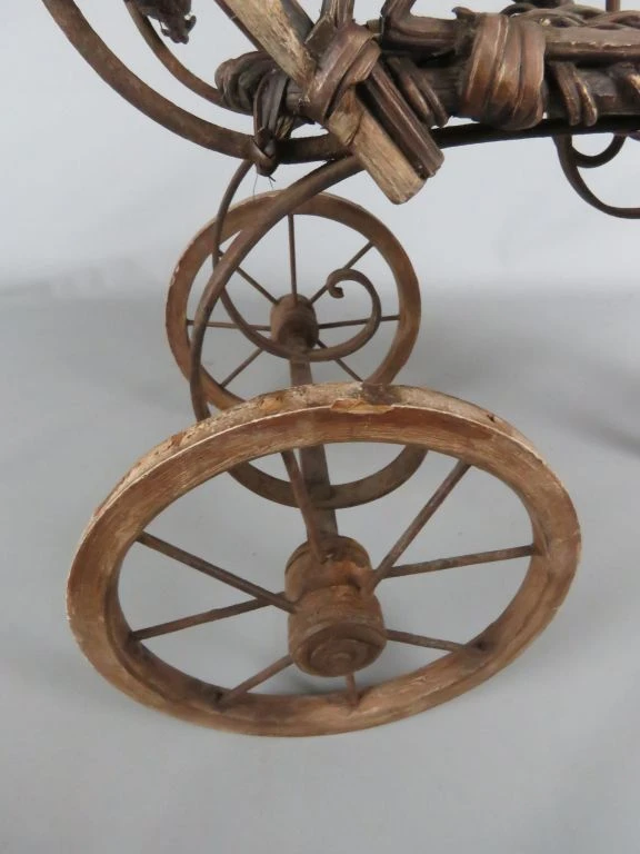 Antieke kinderwagen van riet en hout