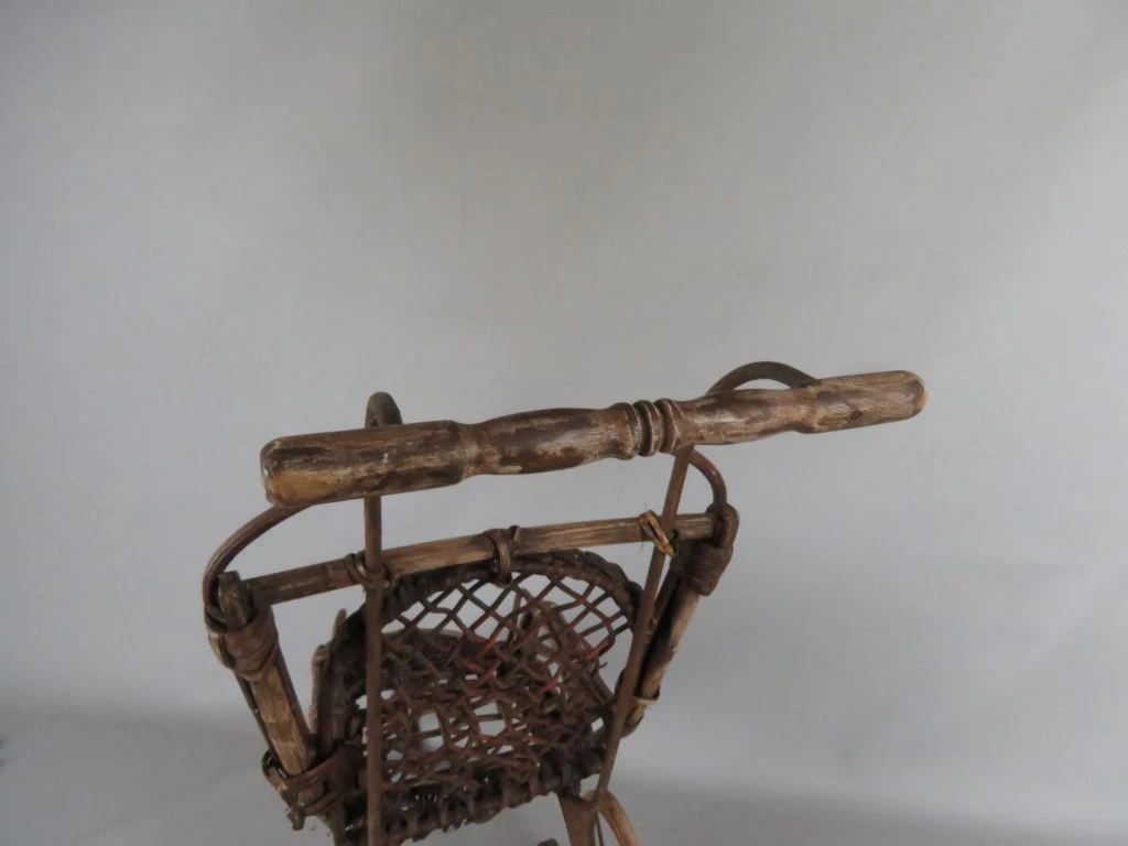 Antieke kinderwagen van riet en hout