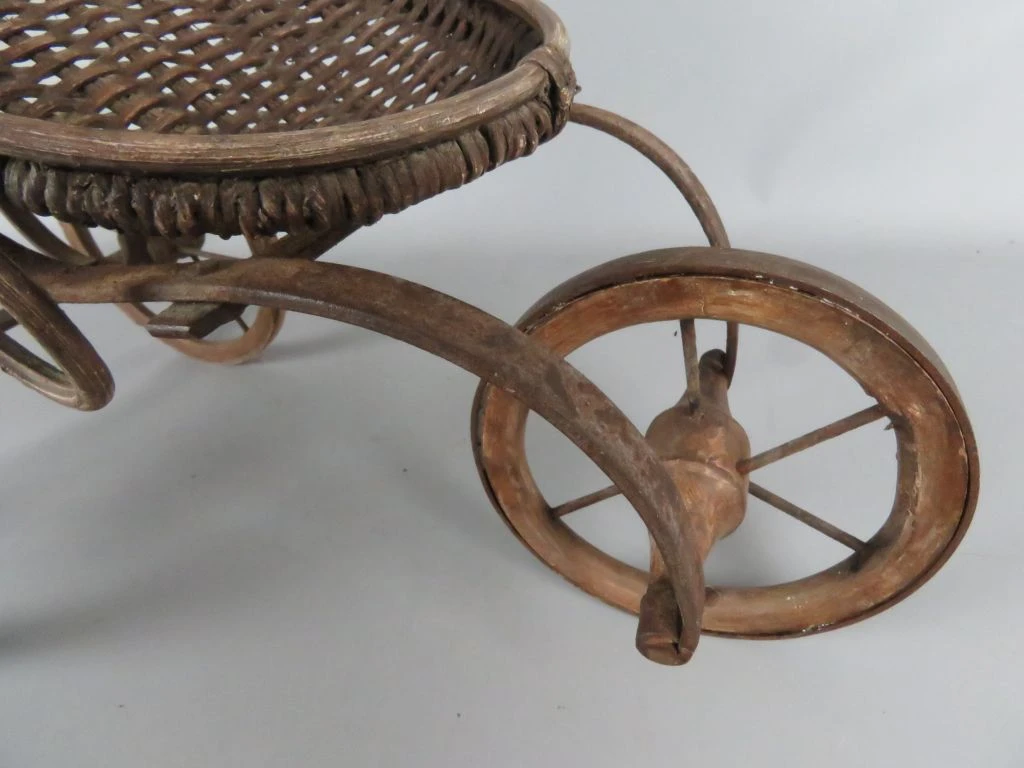 Antieke kinderwagen van riet en hout