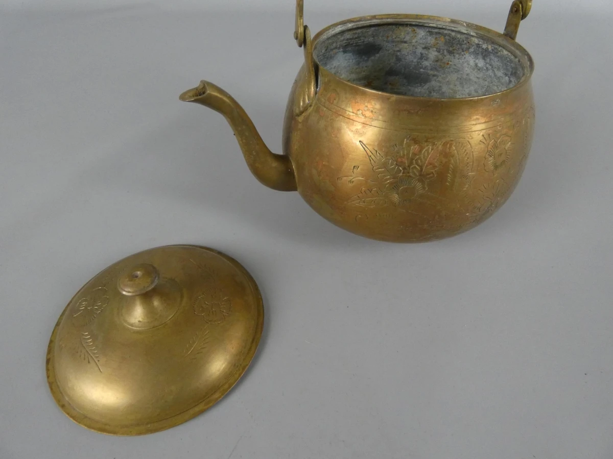 Gegraveerde koperen theepot met houten handvat