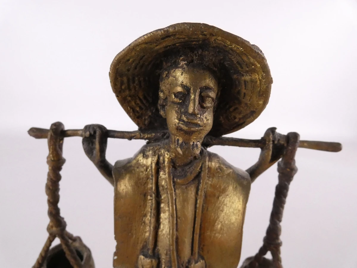 Afrikaans bronzen beeldje van een man die water draagt