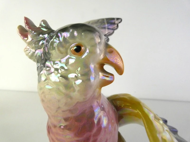 Drie kleurrijke keramische vogelbeeldjes.