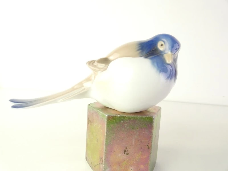 Drie kleurrijke keramische vogelbeeldjes.