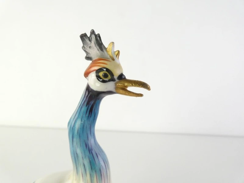 Drie kleurrijke keramische vogelbeeldjes.