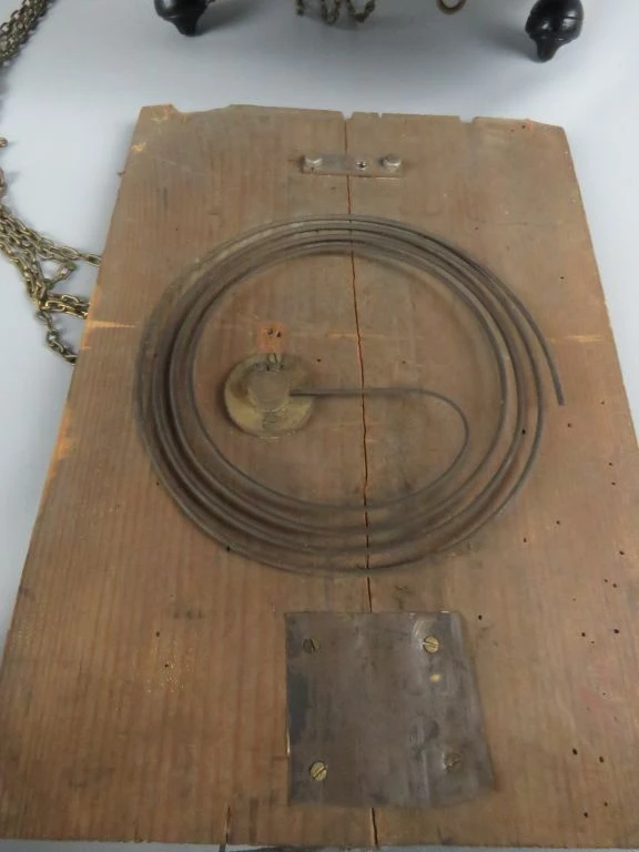 Antieke wandklok met ketting en decoratie