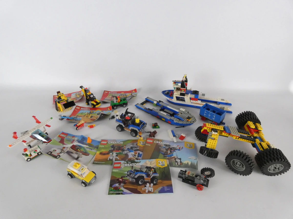 Diverse LEGO bouwsets met voertuigen en handleidingen