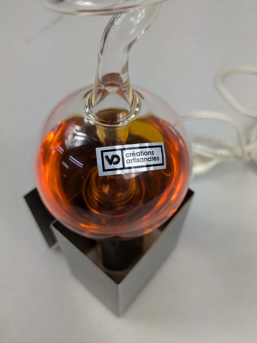 Decoratieve glazen lamp met oranje vloeistof en metalen voet - foto 3