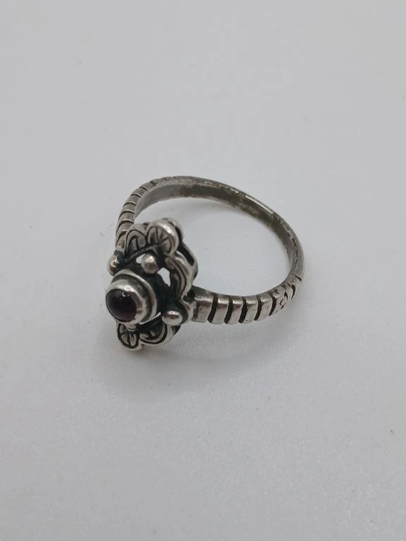 Zilverkleurige ring met rood steentje en bloemmotief - foto 2