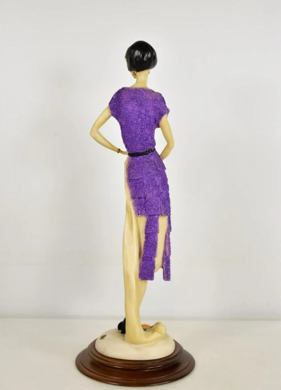 Beeld van vrouw in paarse jurk met waaier in art deco stijl