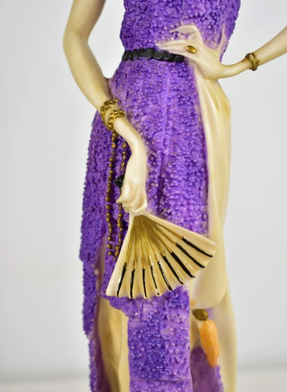 Beeld van vrouw in paarse jurk met waaier in art deco stijl