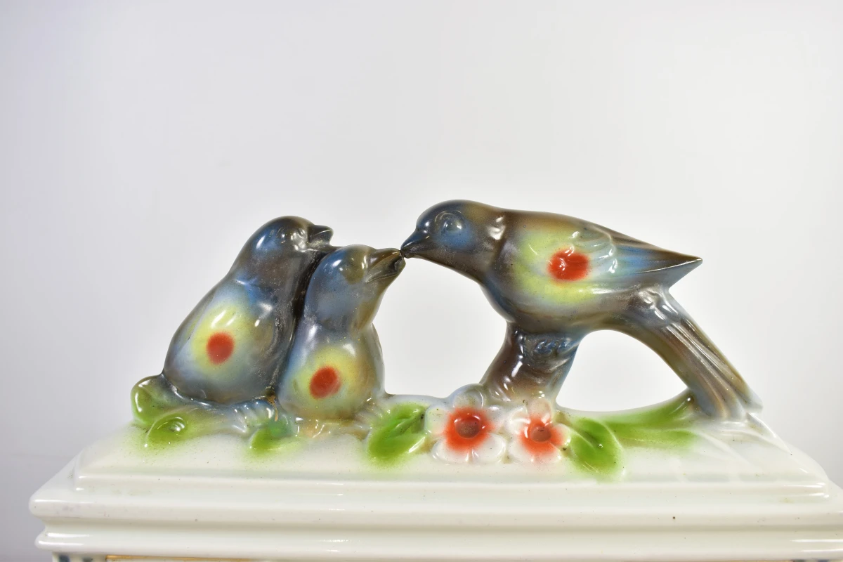 Vintage porseleinen klok met vogeldecoratie