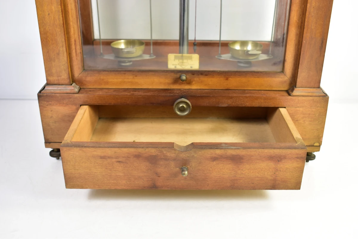 Antieke apothekersweegschaal in houten kast met lade