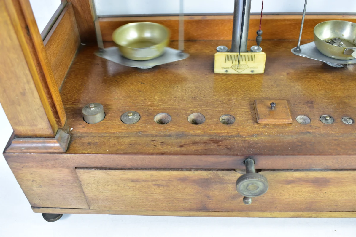 Antieke apothekersweegschaal in houten kast met lade