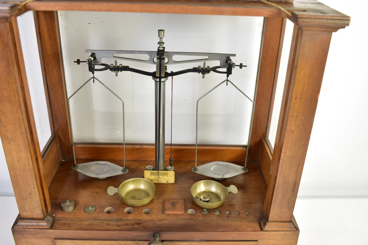 Antieke apothekersweegschaal in houten kast met lade