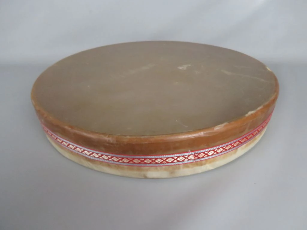 Traditionele handtrommel met decoratieve stoffen band