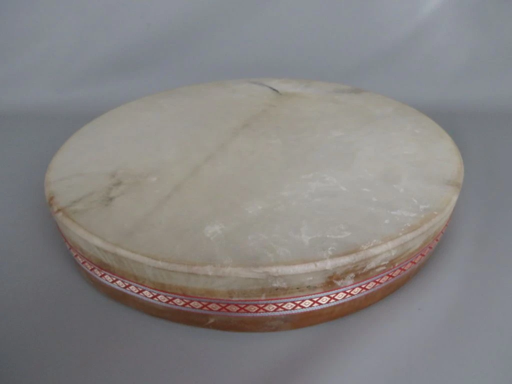 Traditionele handtrommel met decoratieve stoffen band