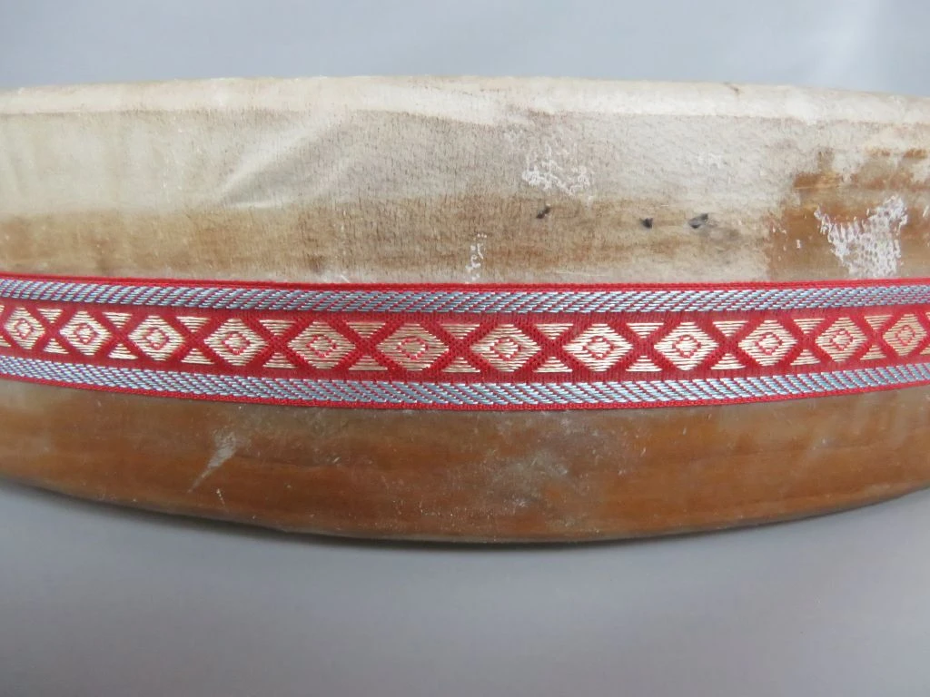 Traditionele handtrommel met decoratieve stoffen band