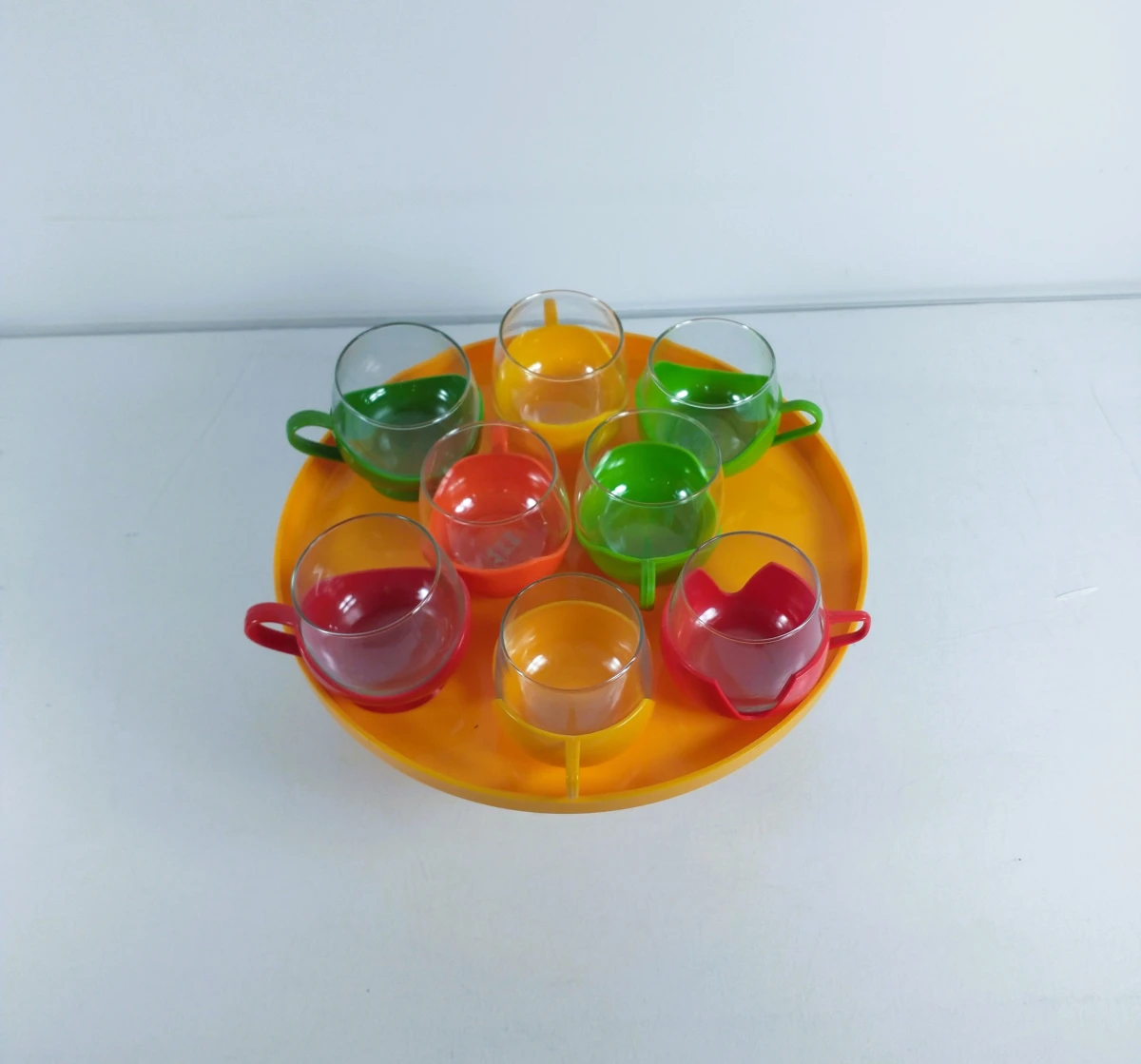 8 glazen kopjes met kunststof houders en serveerblad van het merk Melitta – jaren 70